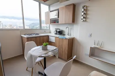 a small kitchen with a small table and chairs at ApartaSuite Central Luxe in Itagüí