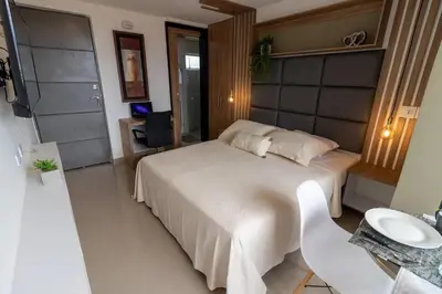 a bedroom with a large white bed and a desk at ApartaSuite Central Luxe in Itagüí