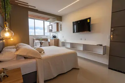 a bedroom with a bed and a tv on the wall at ApartaSuite Central Luxe in Itagüí
