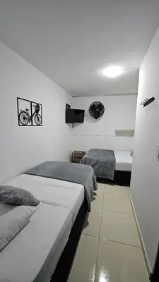 a bedroom with two beds and a flat screen tv at Hotel casa yotama in Medellín