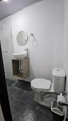 a bathroom with a toilet and a sink and a mirror at Hotel casa yotama in Medellín