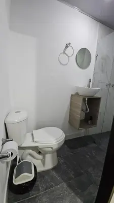 a white bathroom with a toilet and a sink at Hotel casa yotama in Medellín