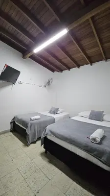 two beds in a white room with at Hotel casa yotama in Medellín