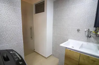 a bathroom with a sink and a white door at Penthouse de Lujo con Jacuzzi y Vista in Itagüí