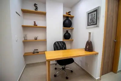 a home office with a wooden desk and a chair at Penthouse de Lujo con Jacuzzi y Vista in Itagüí