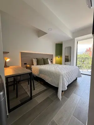 a bedroom with a bed and a table and a window at Apartamento con excelente ubicación, Laureles in Medellín