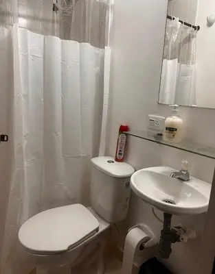 a white bathroom with a toilet and a sink at Excelente Apartamento en Medellín sector Florida Nueva - Estadio in Medellín