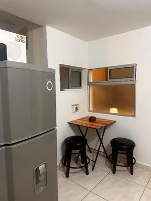 a small kitchen with a table and a refrigerator at Excelente Apartamento en Medellín sector Florida Nueva - Estadio in Medellín