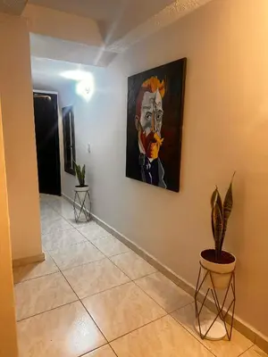 a hallway with a painting of a man on the wall at Excelente Apartamento en Medellín sector Florida Nueva - Estadio in Medellín