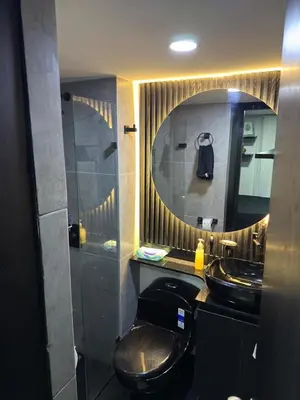 a bathroom with a black toilet and a mirror at Mirador Fiorenza in Medellín