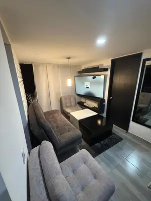 a living room with a couch and a tv at Mirador Fiorenza in Medellín