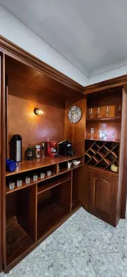 a kitchen with wooden cabinets and a clock on the wall at EmiliasHome Alojamiento amplio en Laureles in Medellín