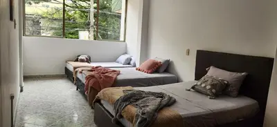 a room with three beds and a window at EmiliasHome Alojamiento amplio en Laureles in Medellín