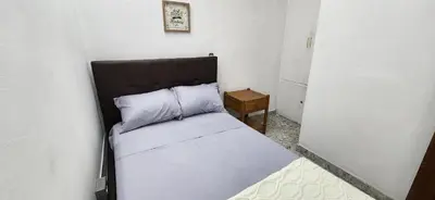 a small bedroom with a bed with a black headboard at EmiliasHome Alojamiento amplio en Laureles in Medellín