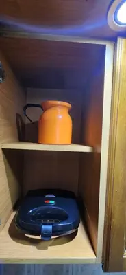 an orange pot sitting on a shelf in a cabinet at EmiliasHome Alojamiento amplio en Laureles in Medellín