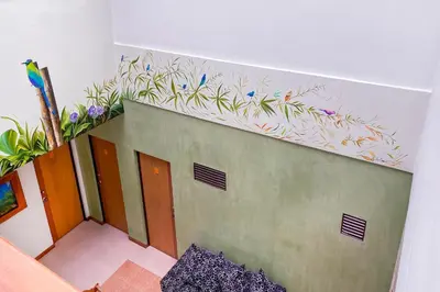a staircase with a painting of flowers on the wall at Ayenda 1140 Roma Plaza in Manizales