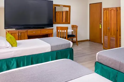 a hotel room with two beds and a flat screen tv at Ayenda 1140 Roma Plaza in Manizales