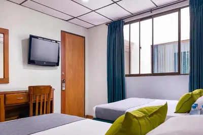 a hotel room with two beds and a tv at Ayenda 1140 Roma Plaza in Manizales