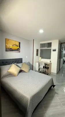 a bedroom with a bed and a desk with a car on the wall at Apto estudio moderno en Sabaneta Ideal para pareja in Sabaneta