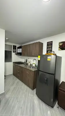 a kitchen with a black refrigerator and a sink at Apto estudio moderno en Sabaneta Ideal para pareja in Sabaneta