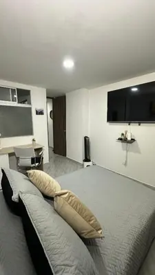 a bedroom with a bed with a television on the wall at Apto estudio moderno en Sabaneta Ideal para pareja in Sabaneta
