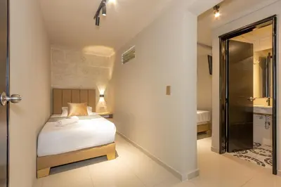 a bedroom with a bed and a bathroom at Hotel Garden Laureles in Medellín