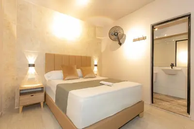 a bedroom with a bed and a bathroom with a sink at Hotel Garden Laureles in Medellín