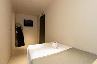 a room with a bed with a towel on it at Hotel Garden Laureles in Medellín