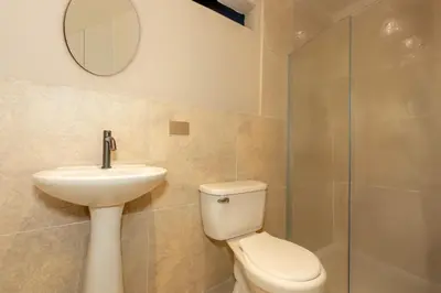 a bathroom with a toilet and a sink and a mirror at Hotel Garden Laureles in Medellín