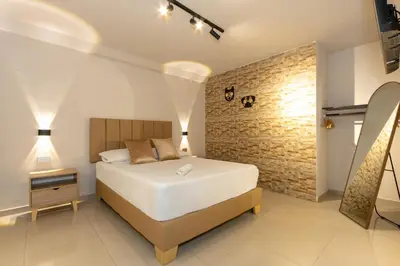 a bedroom with a bed and a brick wall at Hotel Garden Laureles in Medellín