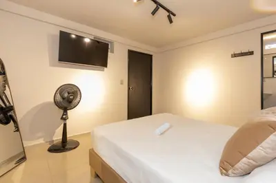 a bedroom with a bed and a fan at Hotel Garden Laureles in Medellín