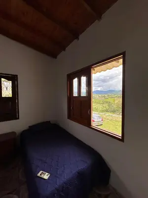 a bedroom with a bed and a window at Finca La Carolina in Jericó