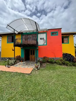 a colorful house with a balcony on top of it at Finca La Carolina in Jericó