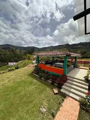a house with a porch and stairs on a hill at Finca La Carolina in Jericó