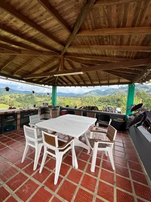 a white table and chairs on a patio with a view at Finca La Carolina in Jericó