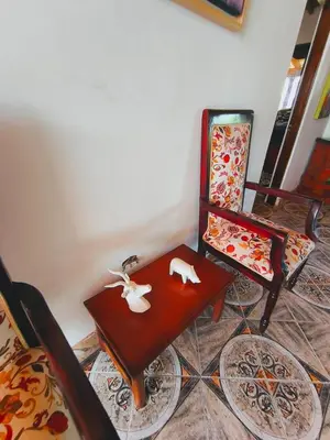 a living room with a table and a chair at Finca La Carolina in Jericó