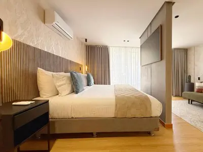 a bedroom with a large bed and a television at Exclusive Studio El poblado in Medellín
