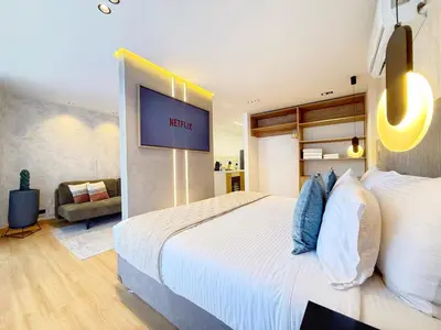 a bedroom with a large bed with a tv on the wall at Exclusive Studio El poblado in Medellín