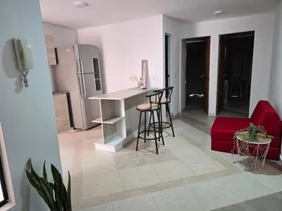 a kitchen and living room with a counter and stools at EstadioMedellin in Medellín