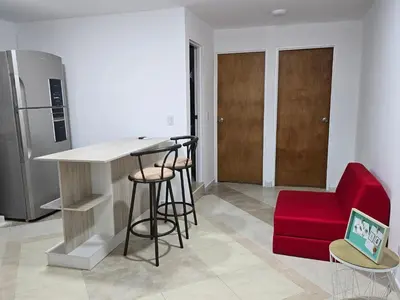 a kitchen with a bar and a red couch at EstadioMedellin in Medellín