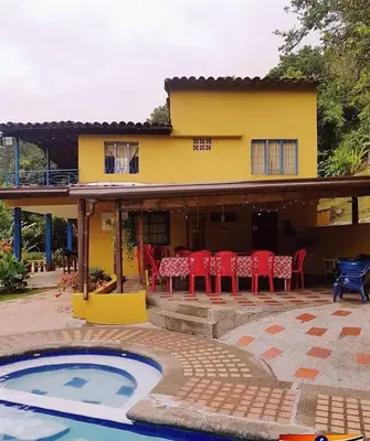 a house with a table and chairs and a pool at Finca Villa Palma in Barbosa