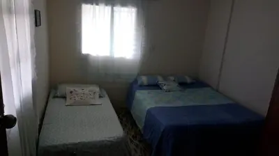 two beds in a small room with a window at Finca Villa Palma in Barbosa