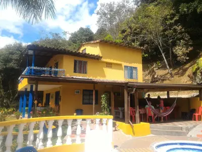 a yellow house with a pool in front of it at Finca Villa Palma in Barbosa