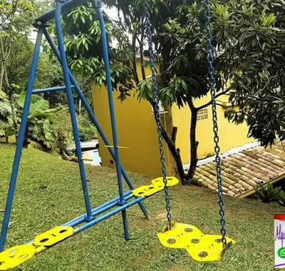 a swing set in a park with yellow rope at Finca Villa Palma in Barbosa