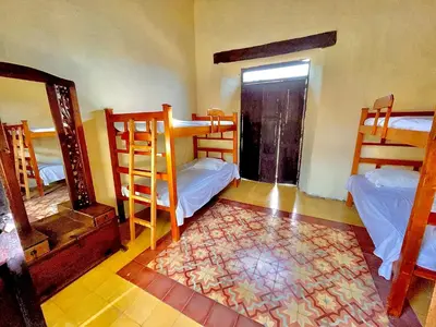 a room with three bunk beds and a mirror at Casa Real - Encanto Colonial in Sopetran