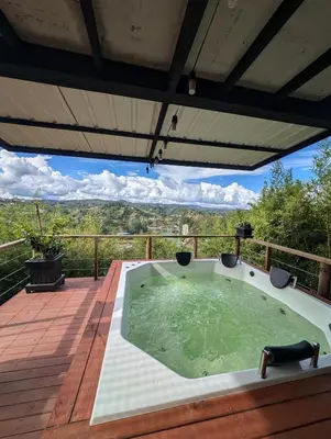 a hot tub on the deck of a house at Cabaña con jacuzzi y vista al embalse - Ocasia in Chiquinquirá