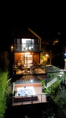 a small house with a deck at night at Cabaña con jacuzzi y vista al embalse - Ocasia in Chiquinquirá