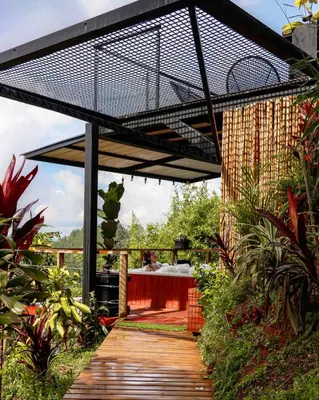 a wooden walkway with a black cage over a table at Cabaña con jacuzzi y vista al embalse - Ocasia in Chiquinquirá