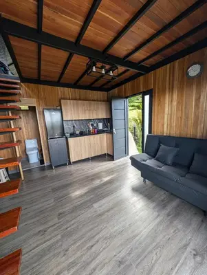 a living room with a couch and a kitchen at Cabaña con jacuzzi y vista al embalse - Ocasia in Chiquinquirá