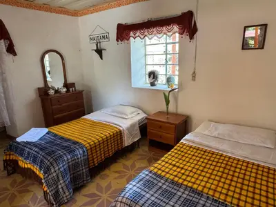 a bedroom with two beds and a window at Casa de campo a 5 minutos from Sonsón in Sonsón